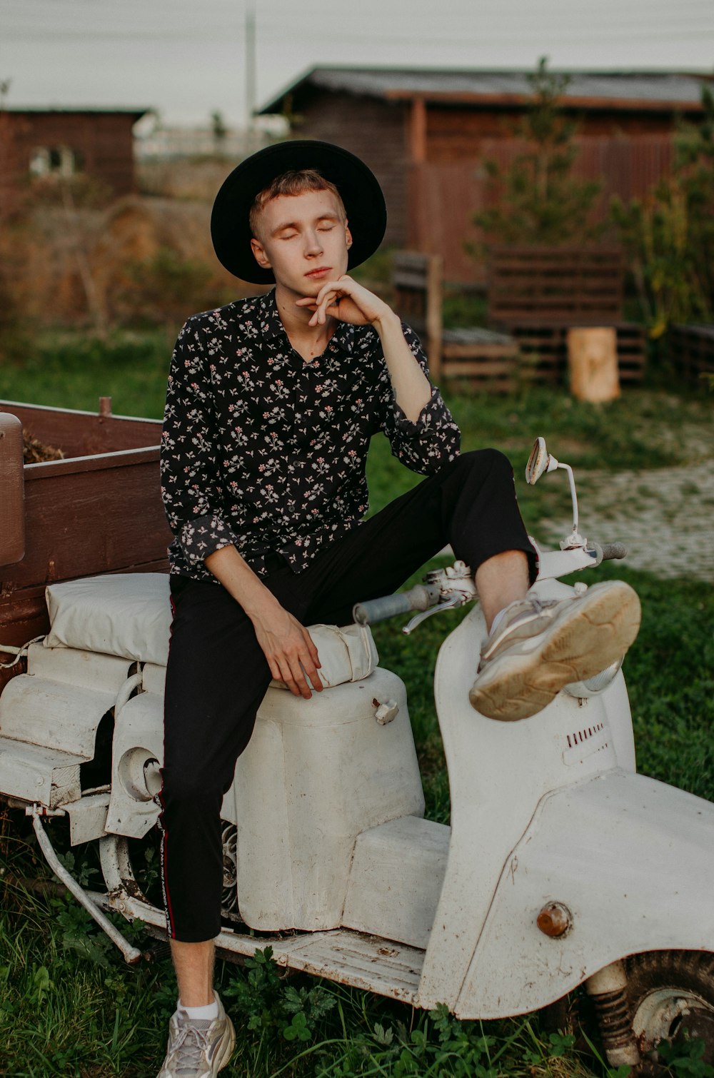 man wearing dress shirt sitting on white motor scooter