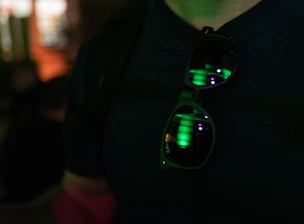 Close-up of sleek smart glasses with colorful transition lenses reflecting city lights at dusk