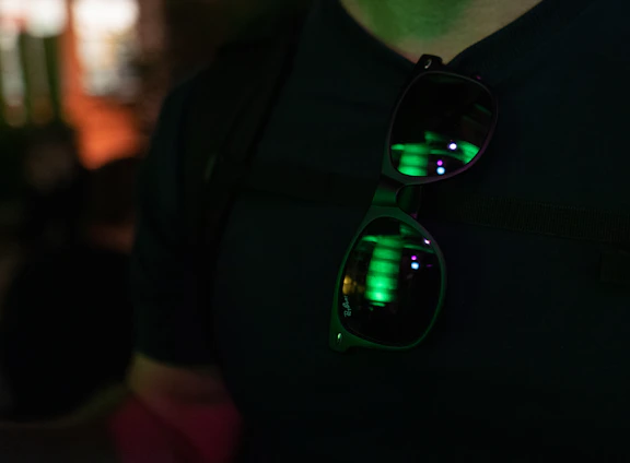 Close-up of sleek smart glasses with colorful transition lenses reflecting city lights at dusk