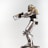 A metallic robot figurine is prominently displayed against a plain background. The robot is equipped with a helmet and a breathing apparatus attached to a backpack. Its body features detailed mechanical joints and armor plating, and it holds a futuristic rifle in its hands.