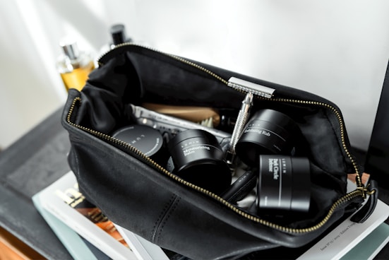 black leather bag with cream containers