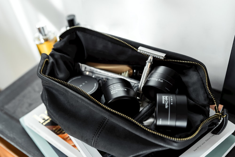 black leather bag with cream containers