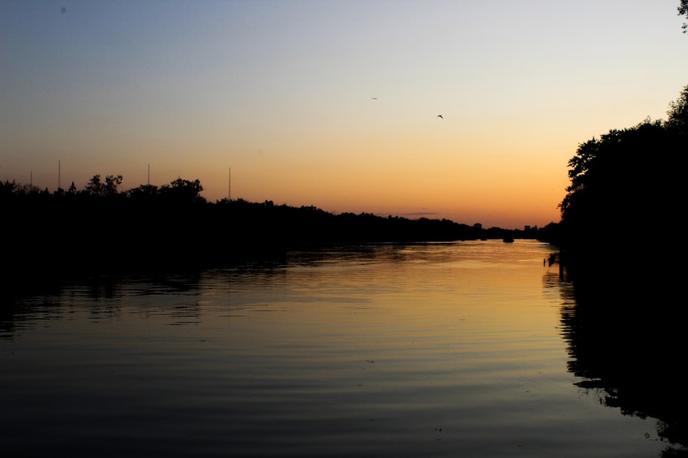 a body of water with a sunset in the background