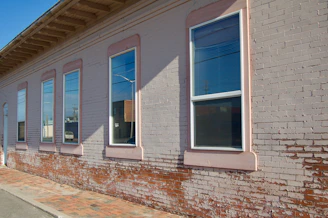 Construction workers laying bricks on a sunny day.