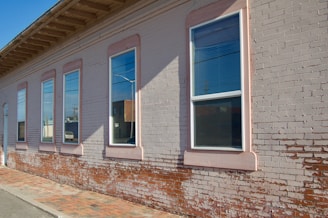 A friendly builder inspecting a brick wall repair on a sunny day.