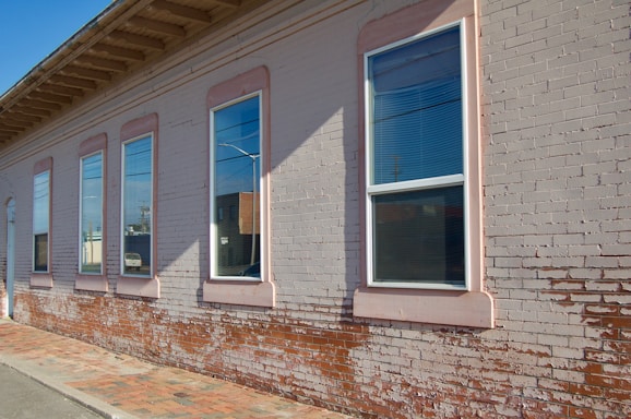 A friendly builder inspecting a brick wall repair on a sunny day.