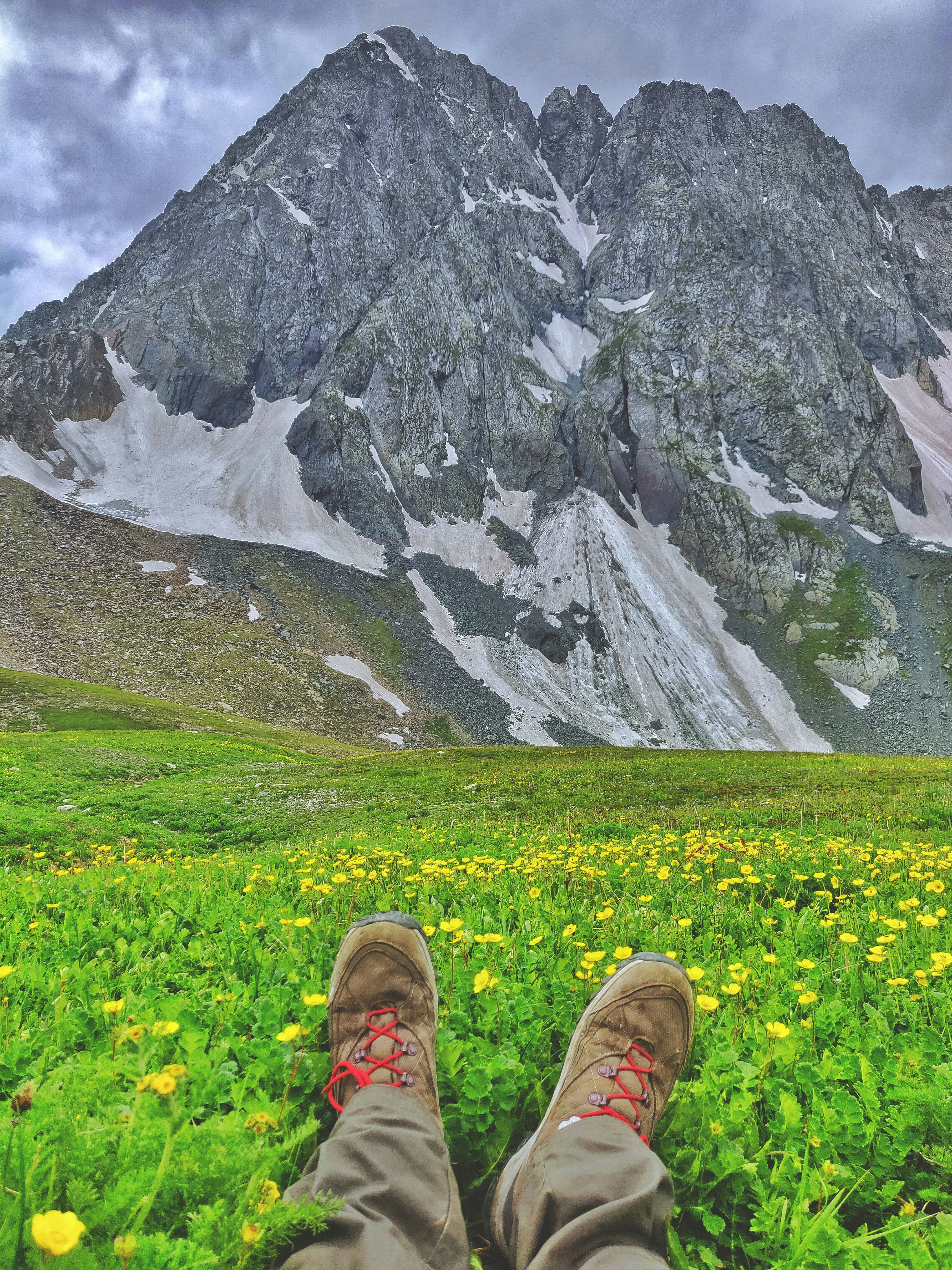 person sitting on grass field near mountain