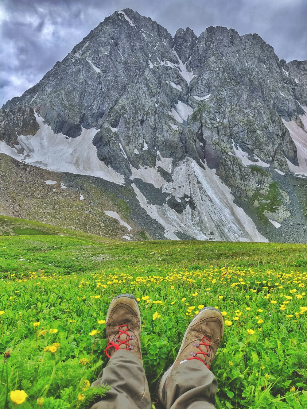 person sitting on grass field near mountain