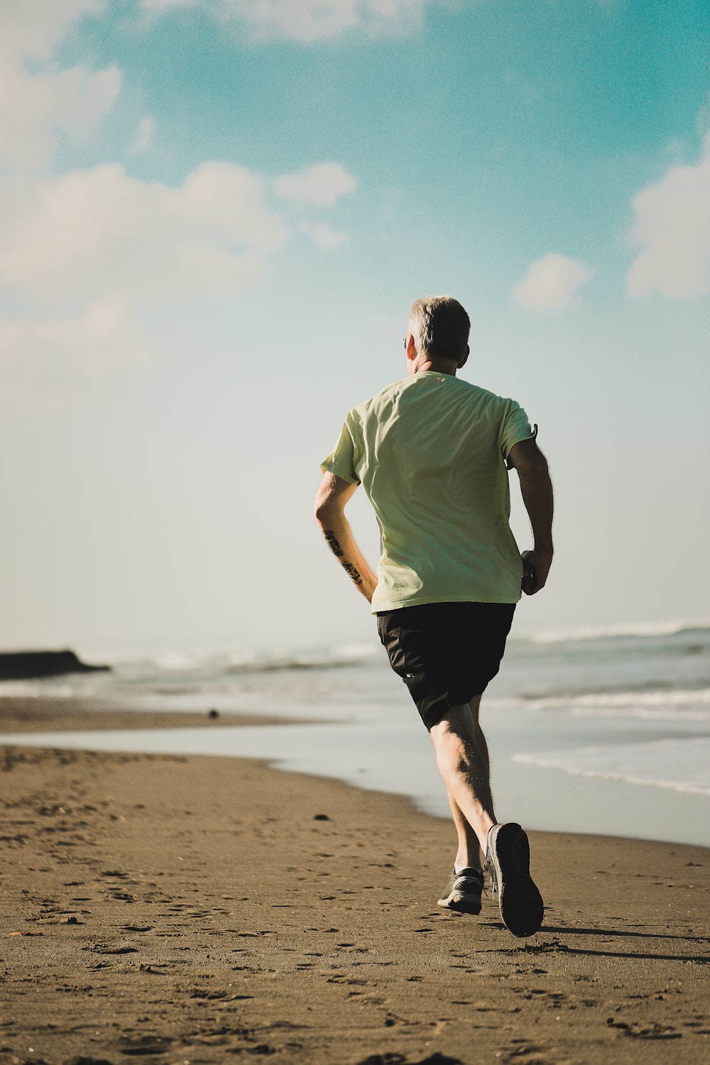 uomo che corre in riva al mare