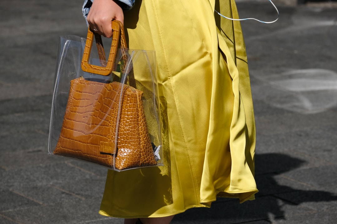 person holding brown leather tote bag