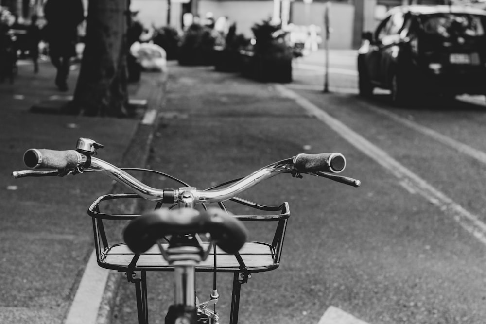 bicycle parked near road during daytime grey-scale photography