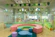 A bright, cozy playroom filled with colorful cushions and natural light where children are happily engaged.