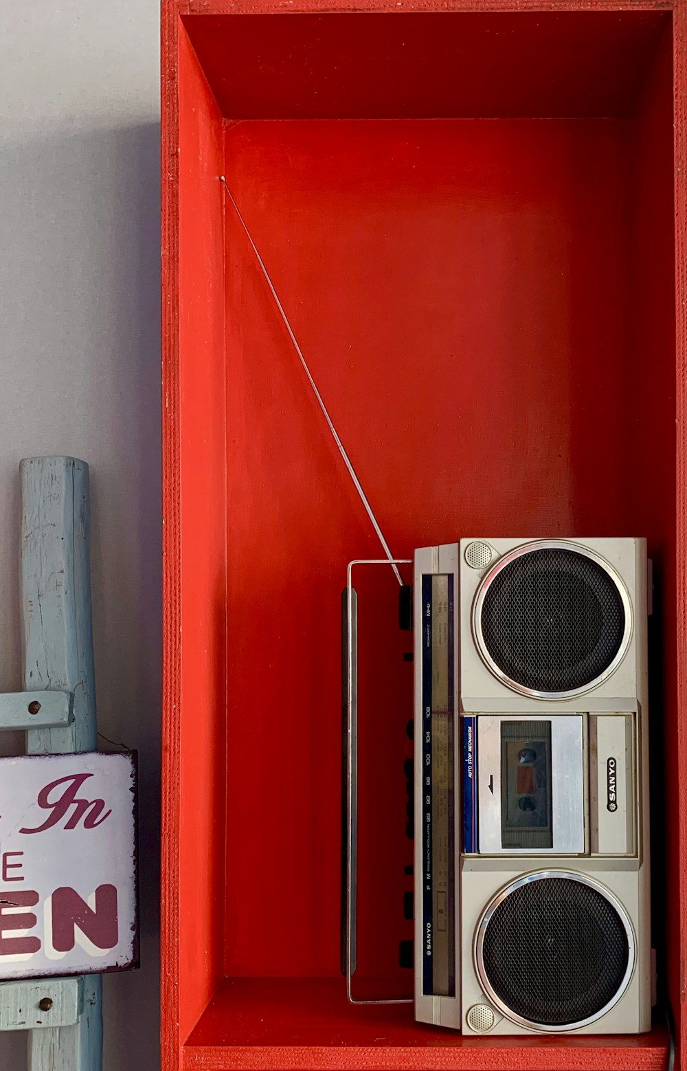 grey and white boom box in shelf