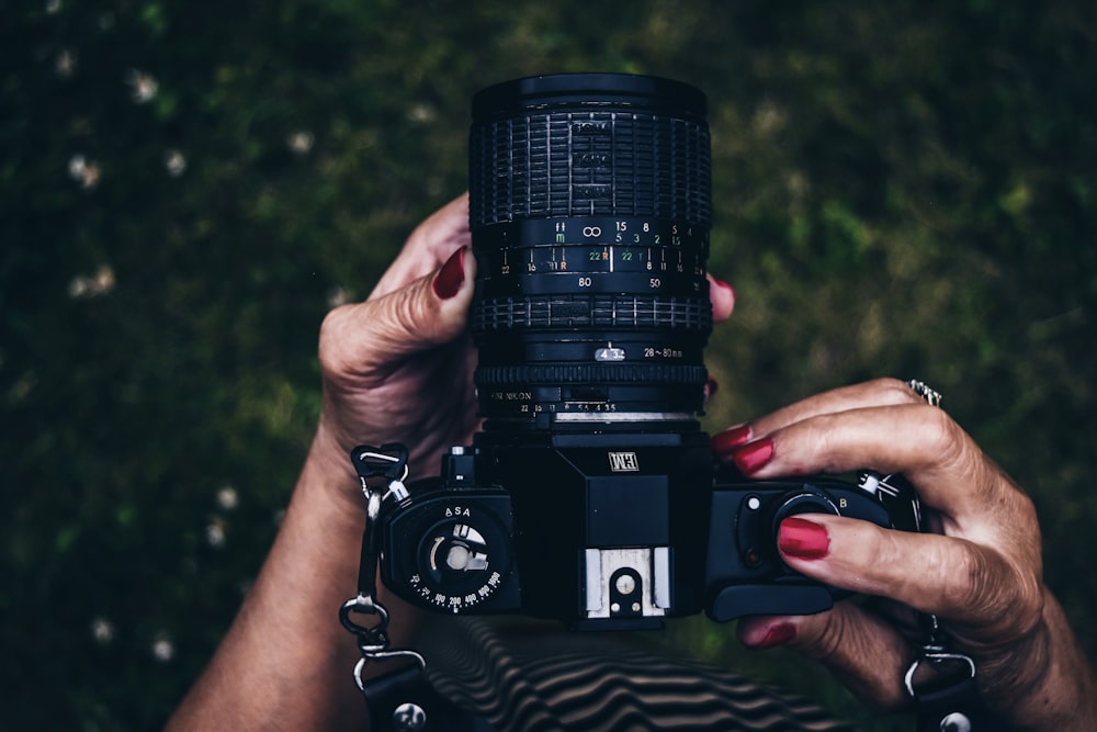 woman holding black DSLR camera