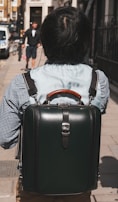 A model wearing a sleek backpack in an urban environment.
