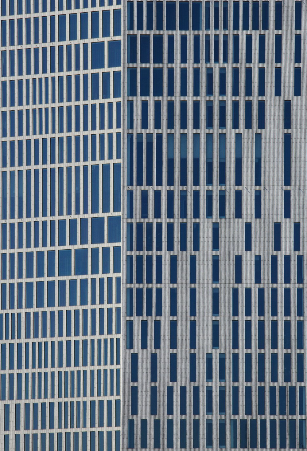 a plane flying in the air next to a tall building