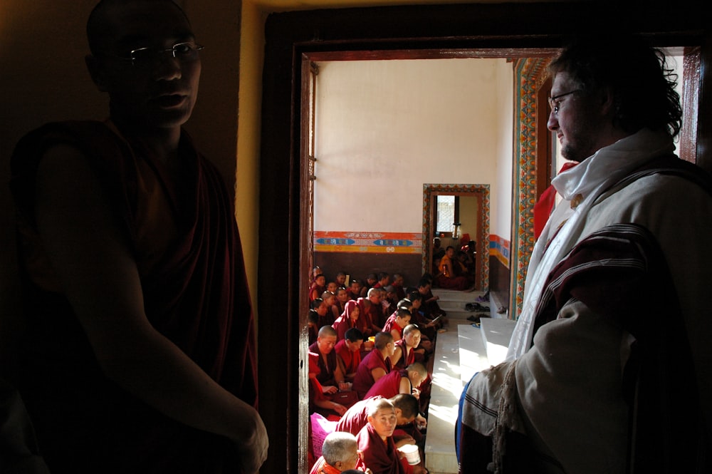 a man standing in front of a doorway next to another man