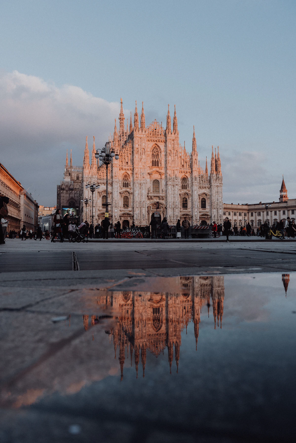 Il Duomo di Milano al tramonto riflesso in una pozza d'acqua in piazza