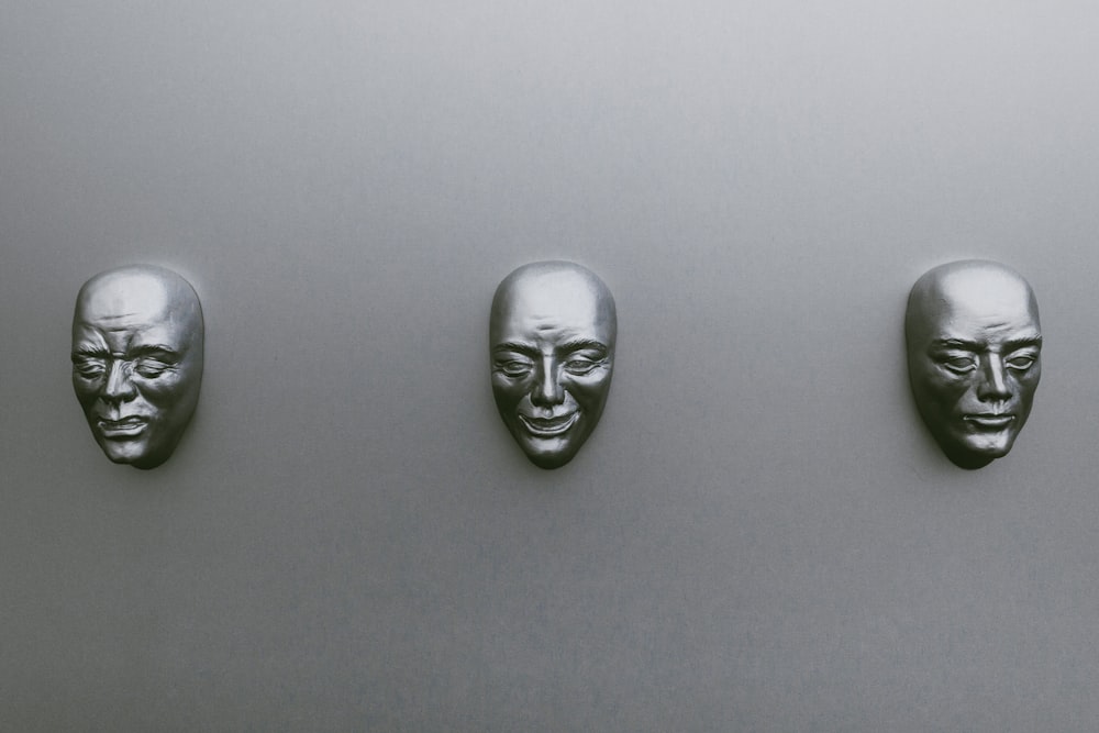 three silver-colored masks