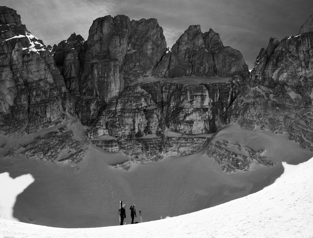 昼間、山のそばに立つ2人の人物の広角撮影