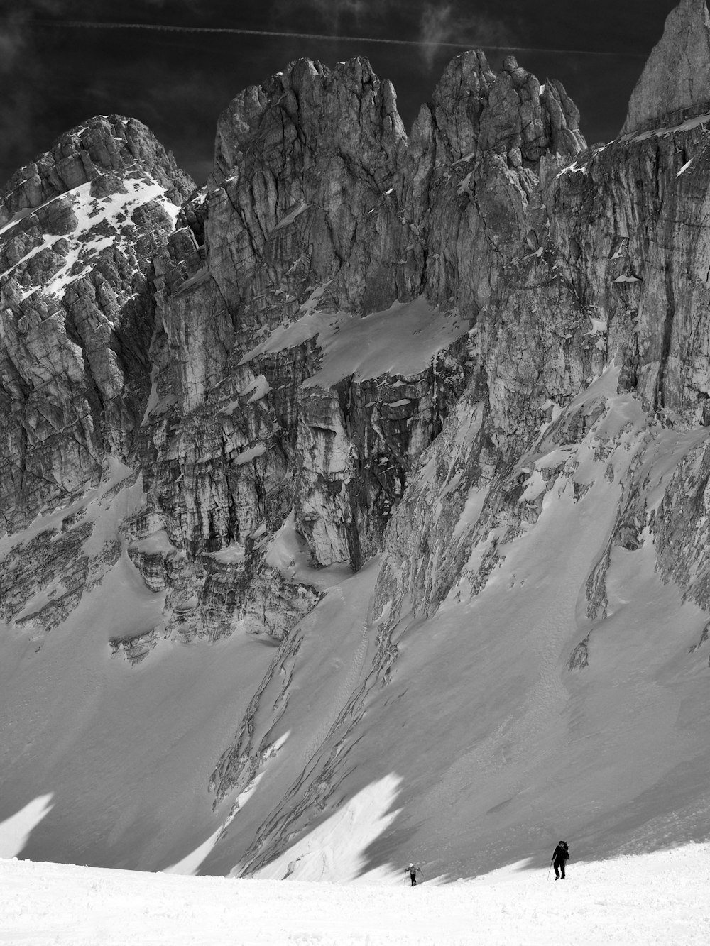 a couple of people standing on top of a snow covered slope