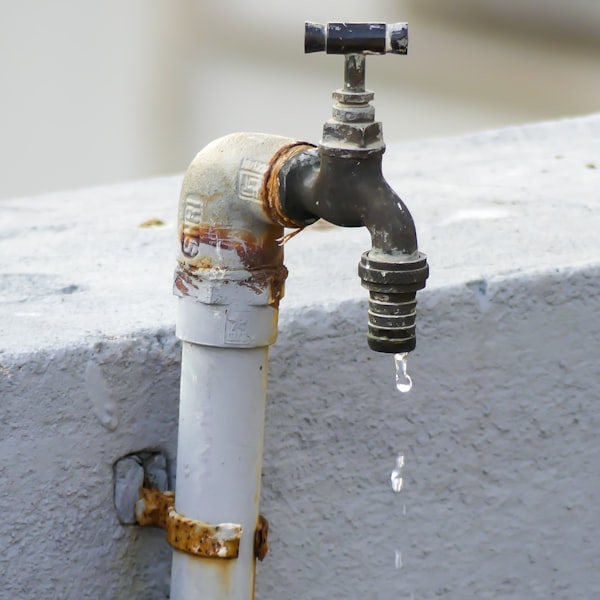 Donkere kraan met waterdruppel