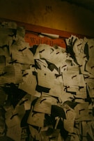 A dense cluster of handwritten notes pinned to a board, labeled 'Wall of Hope'. The notes are of various sizes and orientations, consisting of personal messages and aspirations. The lighting is dim, lending a warm, intimate feel to the scene.