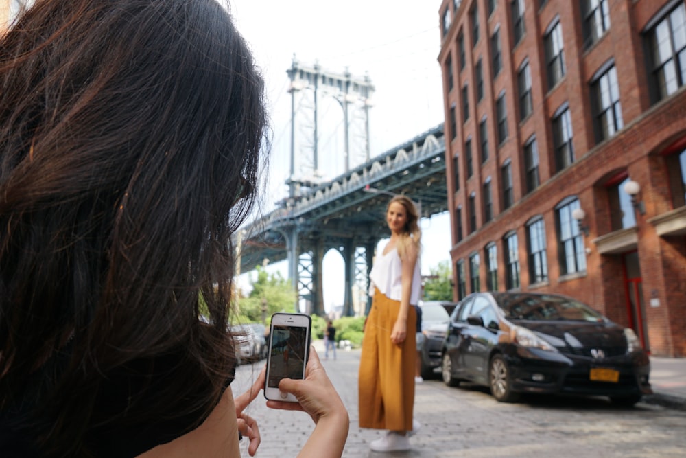 woman taking photo of woman near black vehicle