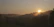 A serene sunrise over the misty paramo landscape near Bogotá, with soft golden light filtering through native trees.