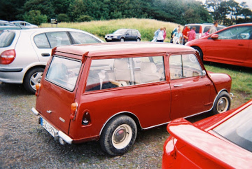 classic red 3-door hatchback parked near vehicles