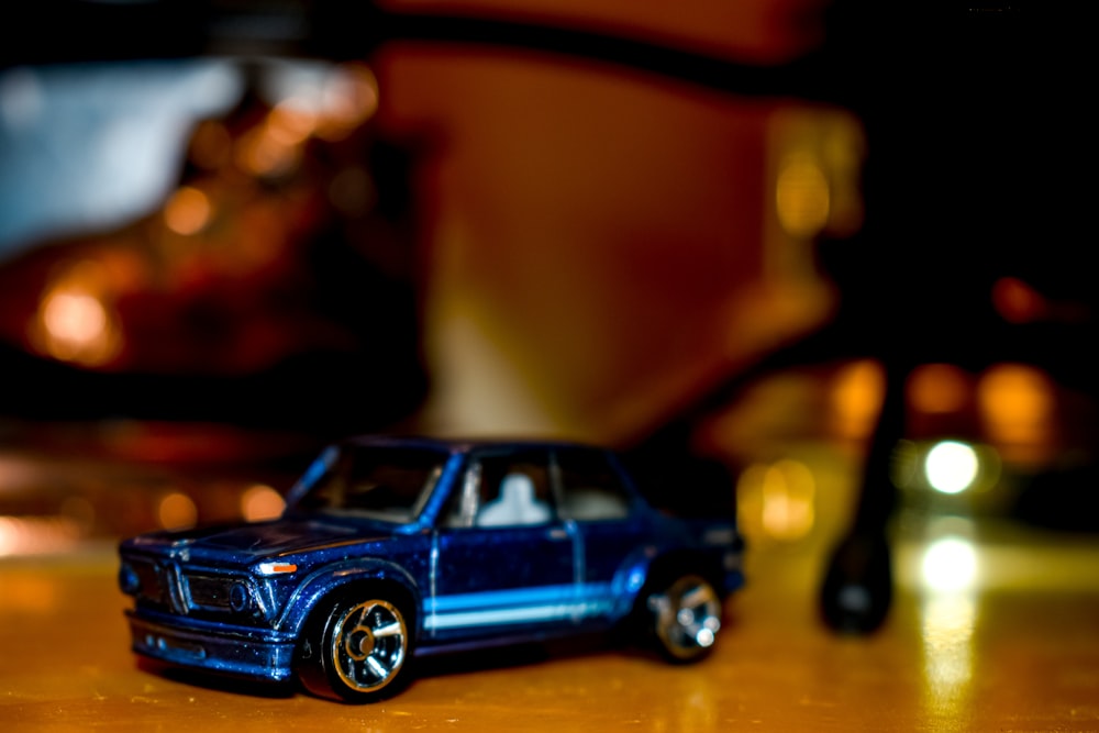 blue coupe toy on brown surface