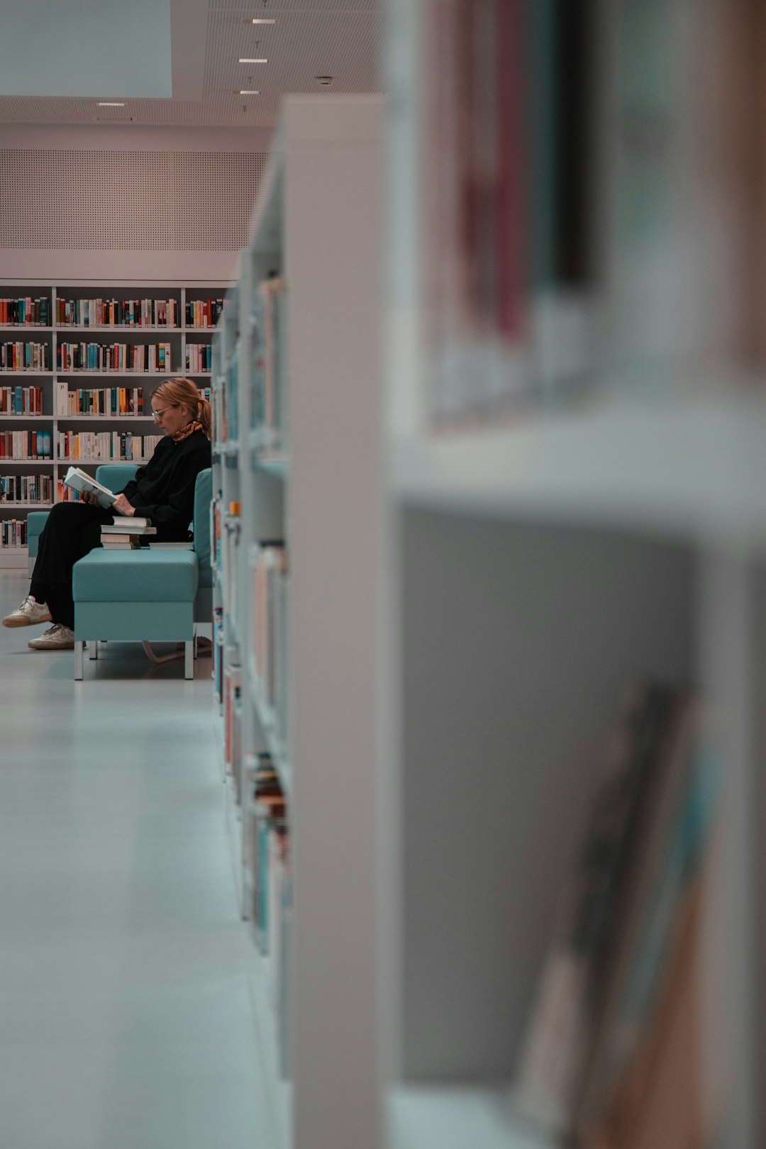 woman sitting beside bookshelves