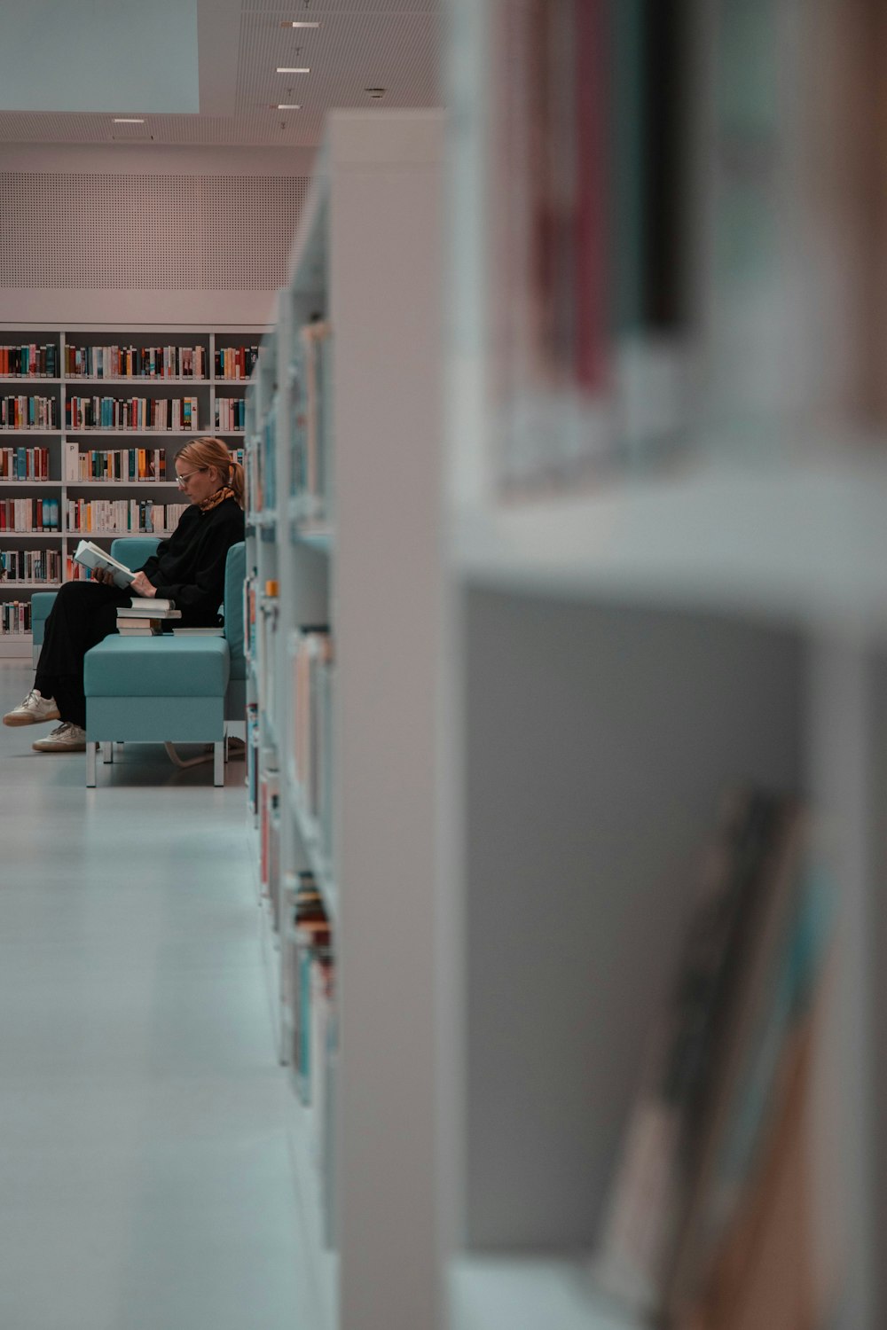 woman sitting beside bookshelves