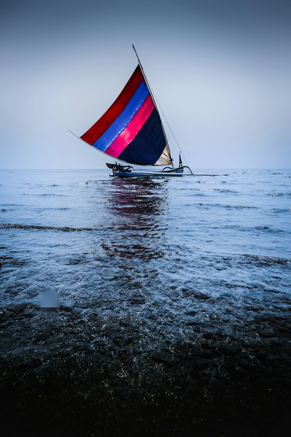 multicolored sailboat on calm water at daytime