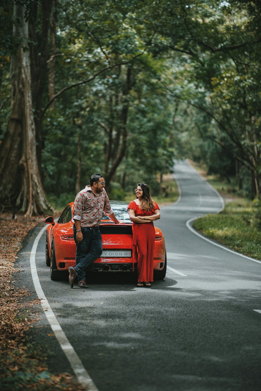 man and woman near orange car