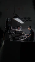 Barista expertly pouring espresso with emerald green accents in a sleek modern café