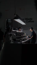 Baristas preparing coffee drinks in a modern, minimalistic coffee event setting.