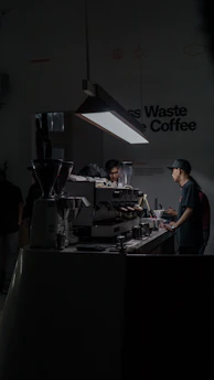 Baristas preparing coffee drinks in a modern, minimalistic coffee event setting.
