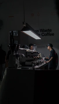 A focused owner managing inventory and quality control in a sleek beverage preparation area.