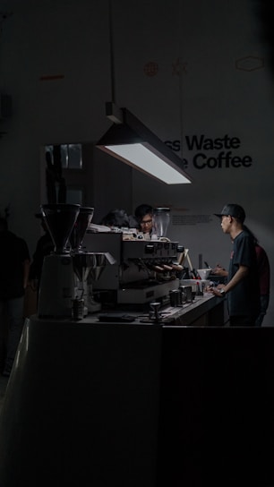 A warm, modern café setting with a barista training a small group, surrounded by sleek coffee equipment.