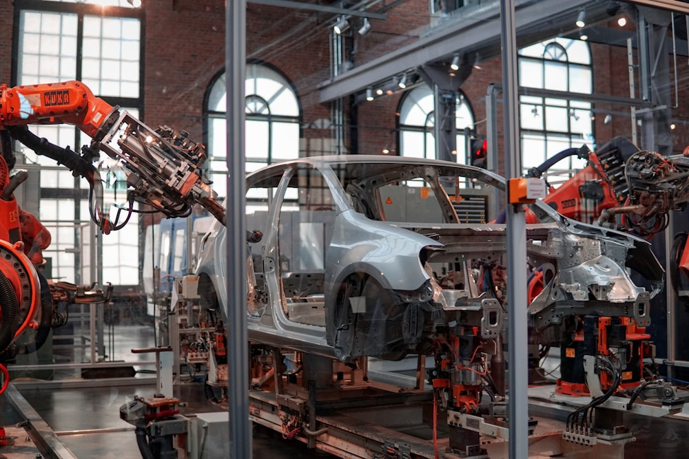 Robots work on a car chassis as part of a production line in a factory