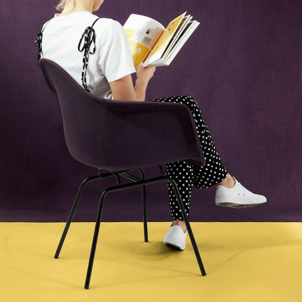 woman sitting with crossed legs while reading book