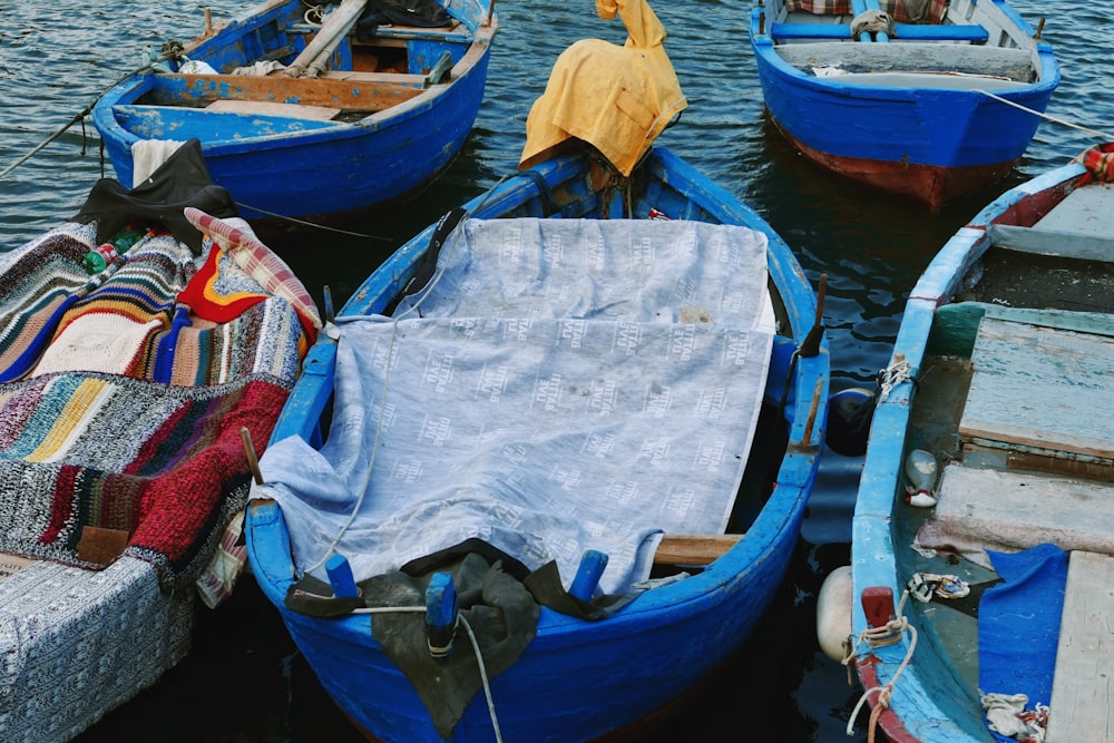 blue wooden boats on body of water