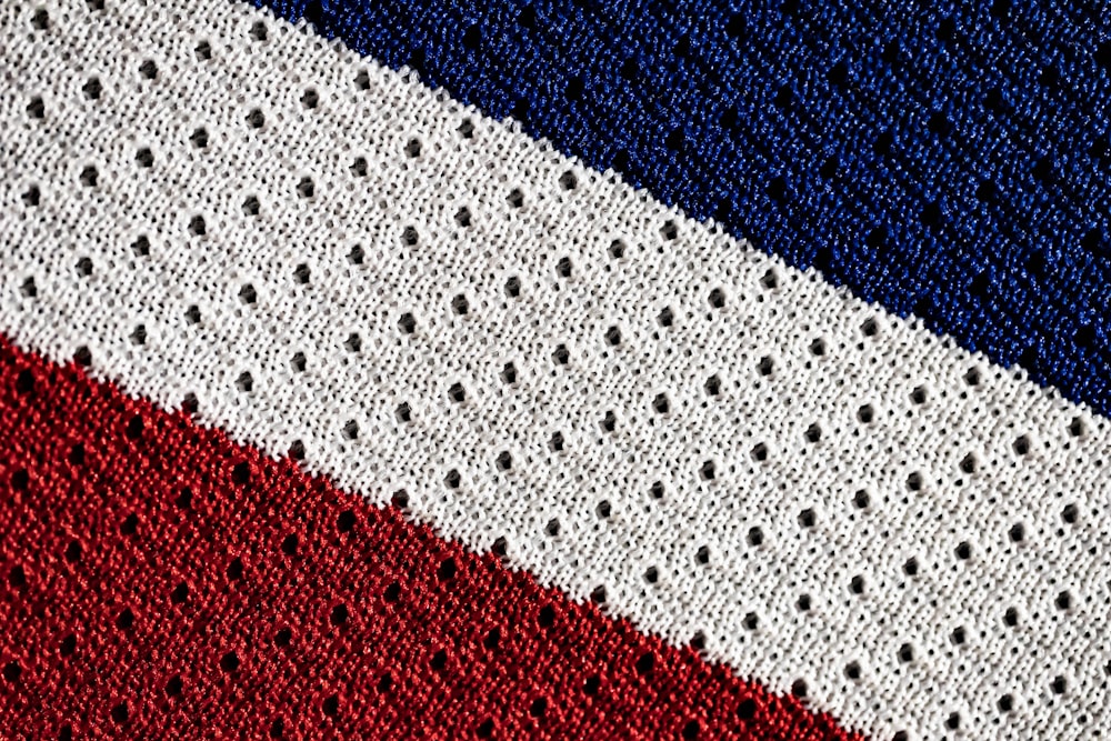 a close up of a red white and blue knitted blanket
