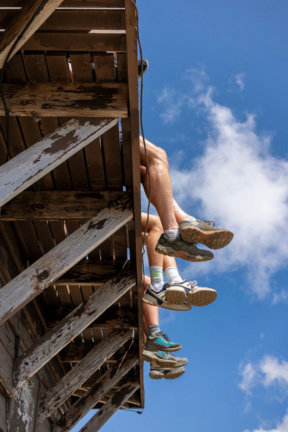 thee person sitting on wooden dock