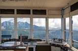 Modern rustic cabin with large windows overlooking mountain views.