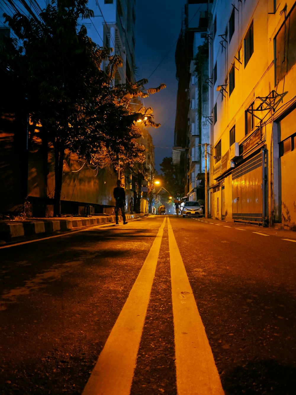 person waling near road during night time