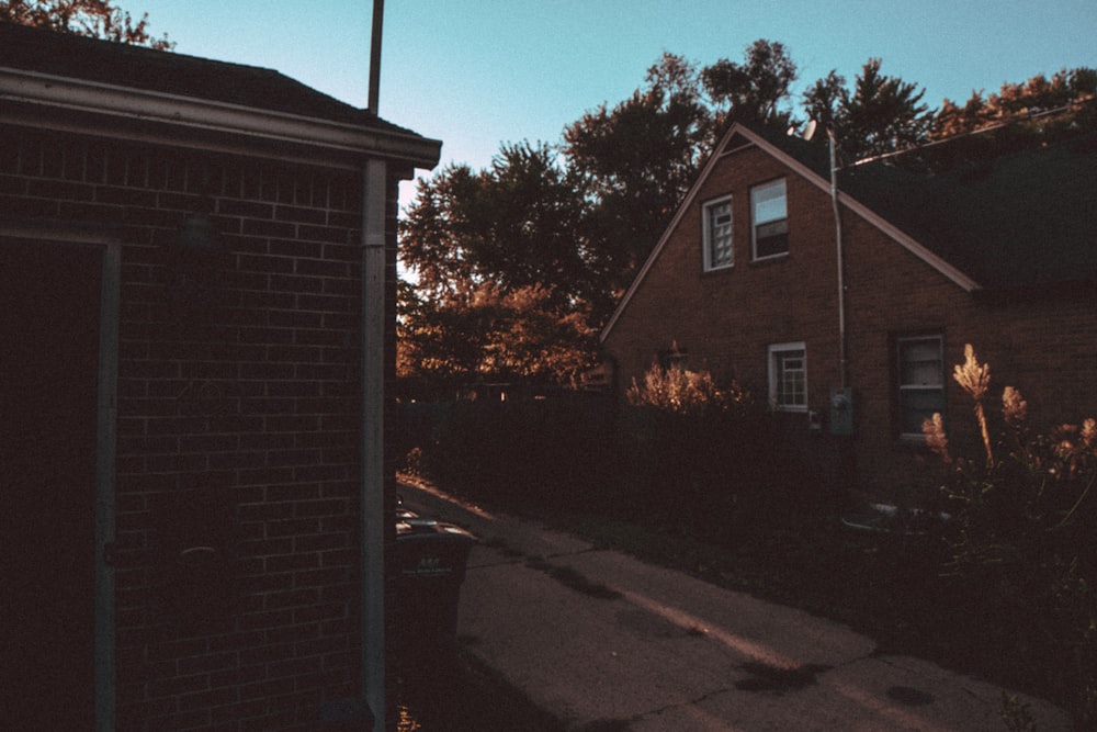 road between two brown houses during daytime