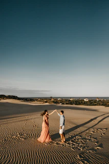 A joyful couple dancing under the warm Jordanian sun with camels nearby.