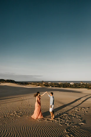 A joyful couple dancing under the warm Jordanian sun with camels nearby.